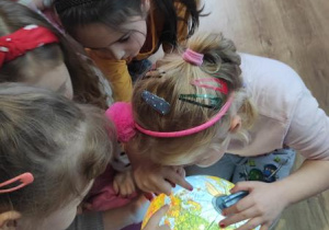 Dzieci wskazują położenie Francji na globusie.